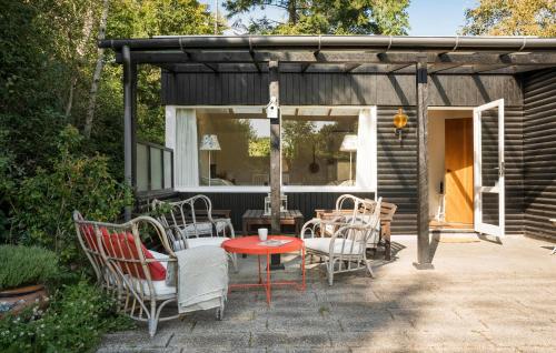 a patio with chairs and a table with at 2 Bedroom Lovely Home In Dronningmølle in Dronningmølle