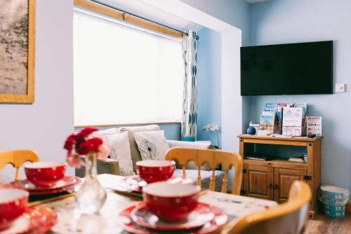 a dining room with a table with red dishes on it at 1 Bed Sleeps 2 Free Parking Pets Welcome in East Dereham