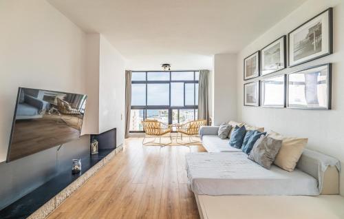 トレモリノスにあるCozy Apartment In Torremolinosの白いソファとテレビのあるリビングルーム