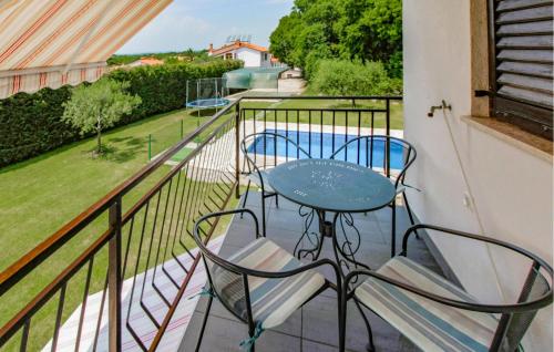 a balcony with a table and chairs and a pool at Amazing Home In Labin in Labin