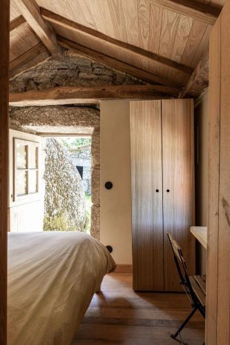 a bedroom with a bed and a desk and a window at Levada da Breca - Turismo Rural in Ervedeiros