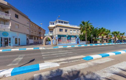 eine leere Straße mit einem Gebäude und Palmen in der Unterkunft Cozy Apartment In San Pedro Del Pinatar in San Pedro del Pinatar