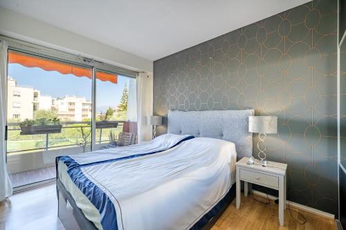 尼斯Superbe 2 pièces Clim et Parking的一间卧室，里面有一张床和一扇大窗户。