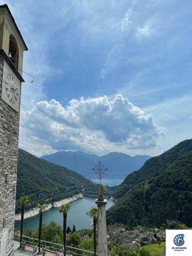 a clock tower with a view of a river at Bright studio with panoramic view of Valle Verzasc in Mergoscia