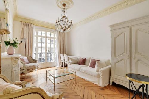 - un salon avec un canapé et un lustre dans l'établissement Trocadero - Longchamp 2bdr, à Paris