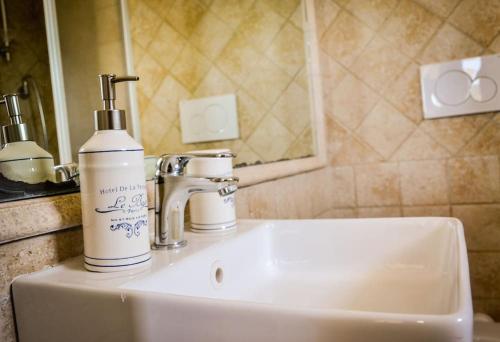 a bathroom sink with a bottle of soap on it at Il Mare a Roma - Attico Fronte Mare in Lido di Ostia