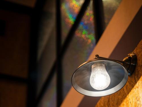 a light hanging on a wall with a stained glass window at eeGee STAY Kamata in Tokyo