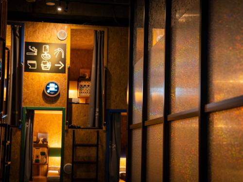 a view through the doors of a building with a sign at eeGee STAY Kamata in Tokyo