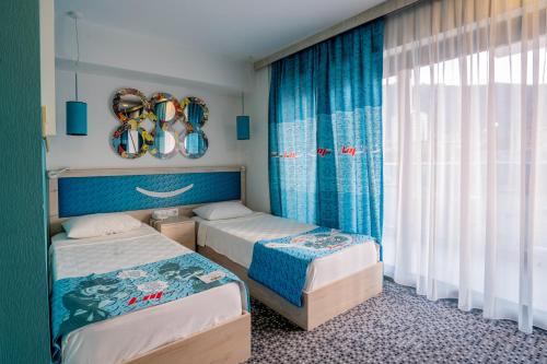 a bedroom with two beds and a window at Leman Otel in Denizli