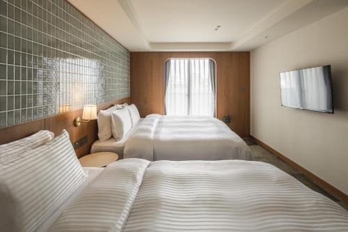 Postel nebo postele na pokoji v ubytování 天下南隅 Provintia Hotel