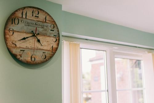 a clock hanging on a wall next to a window at 1 Bed Sleeps 2 Free Parking Pets Welcome in East Dereham