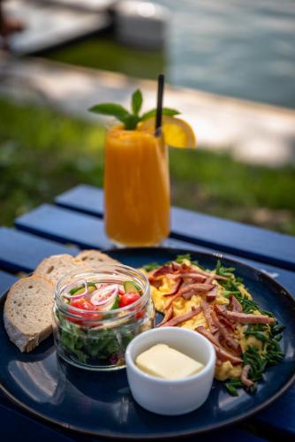a blue plate with a salad and a sandwich and a drink at Nautica Resort in Giżycko