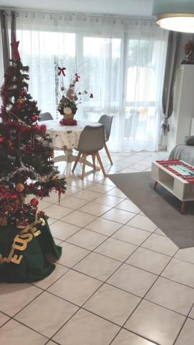 a living room with a christmas tree on a tiled floor at Appartement de 51 m2 avec jardin de 51 m2, parking privé in Achères