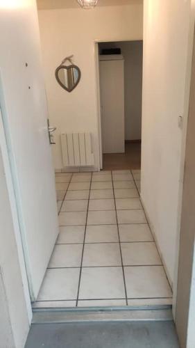 an empty hallway with a door and a tile floor at Appartement de 51 m2 avec jardin de 51 m2, parking privé in Achères