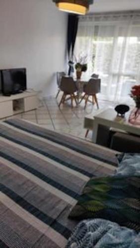 a bedroom with a bed and a living room at Appartement de 51 m2 avec jardin de 51 m2, parking privé in Achères