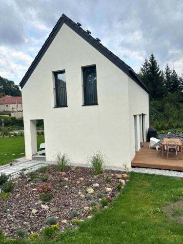 a white house with a deck and a patio at MINIMAL. Dom całoroczny w górach in Duszniki Zdrój
