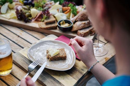 a woman sitting at a table with a plate of food at Arlberg Stuben - das kleine, feine Hotel in Stuben am Arlberg