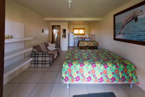 a bedroom with a bed and a living room at Pousada Moradas do Sol Nascente in Passo de Torres