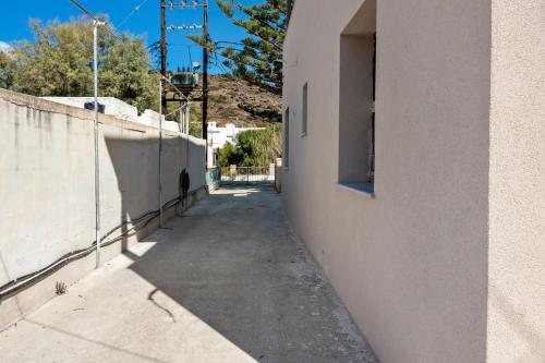 an alleyway between a building and a wall at Sunset Realty Apartment in Ano Syros