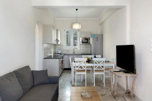 a living room and kitchen with a couch and a table at Sunset Realty Apartment in Ano Syros