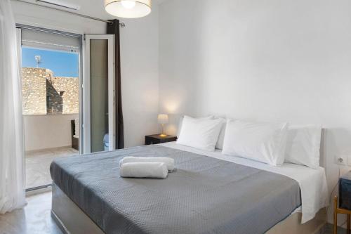 a bedroom with a bed with a towel on it at Sunset Realty Apartment in Ano Syros