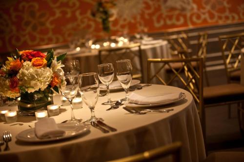 a table with wine glasses and a vase of flowers at Hotel Lombardy in Washington