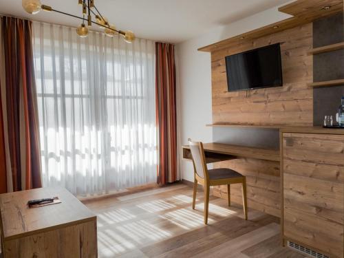 a hotel room with a desk and a television at Hotel Geiger in Füssen
