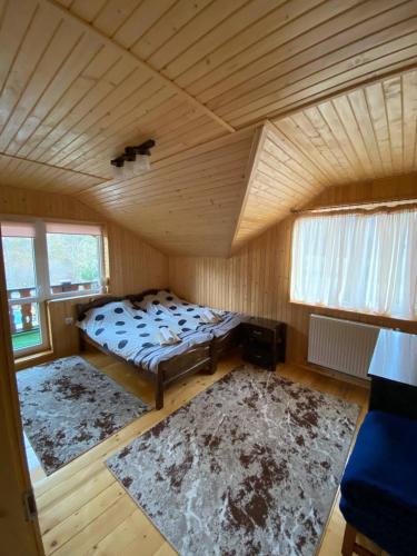 a bedroom with a bed and two rugs in a room at Sova in Lazeshchyna