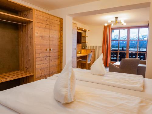 a bedroom with a large white bed with a view at Hotel Geiger in Füssen