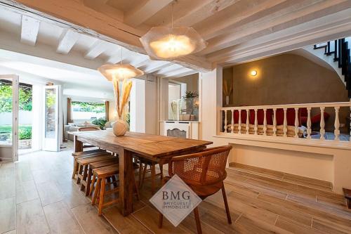 a dining room with a wooden table and chairs at Villa Solaris Disneyland in Chalifert