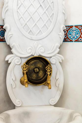 a gold object in a white wall at Tafoni Houses Cave Hotel in Ortahisar