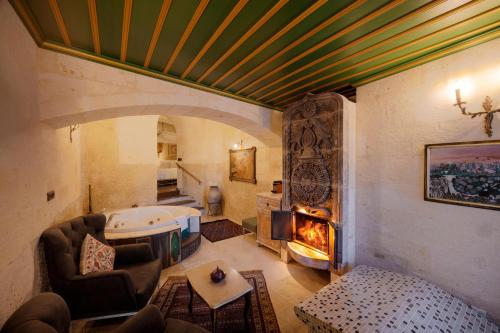 a living room with a couch and a fireplace at Tafoni Houses Cave Hotel in Ortahisar