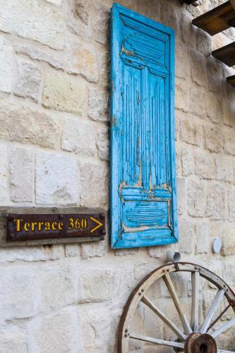 a blue door and a sign on a wall with a wheel at Tafoni Houses Cave Hotel in Ortahisar