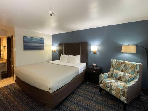 a hotel room with a bed and a chair at Quality Inn Ontario Airport Convention Center in Ontario