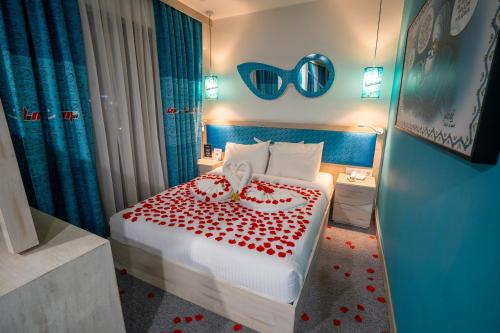a hotel room with a bed with red hearts on it at Leman Otel in Denizli