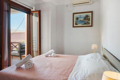 a bedroom with a bed with two towels on it at Voula Apartment in Ermoupoli