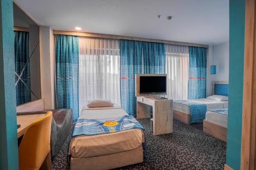 a hotel room with two beds and a television at Leman Otel in Denizli