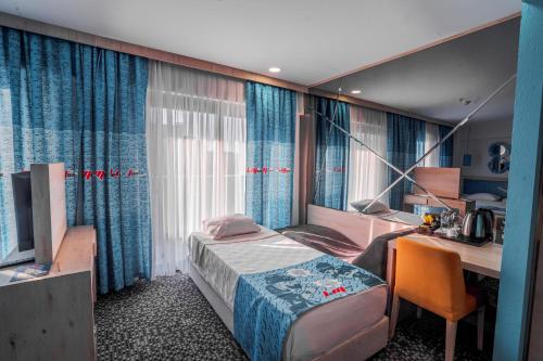 a hotel room with a bed and a desk and a desk at Leman Otel in Denizli