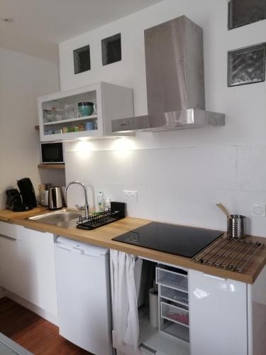 une cuisine avec des armoires blanches et un comptoir en bois dans l'établissement Studio dans maison de ville, à Toulouse
