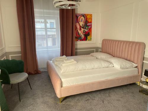 a bed in a room with a chair and a window at Boutique Hotel Pošta RL in Oravský Podzámok