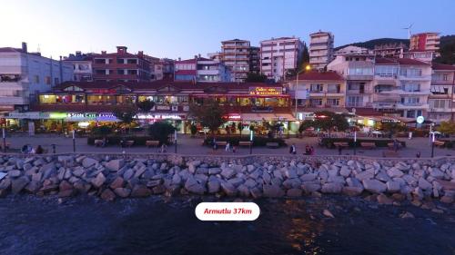 a city at night with a sign in the water at Yalova Lova Hotel & SPA Yalova in Yalova