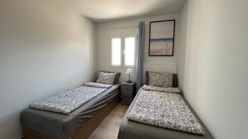 a room with two beds and a window at Casa Fin del Mundo El Cotillo in Cotillo