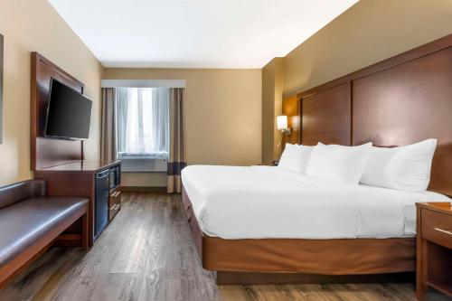 a hotel room with a large bed and a television at Comfort Suites At the University in Conway