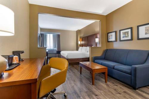 a hotel room with a couch and a bed at Comfort Suites At the University in Conway