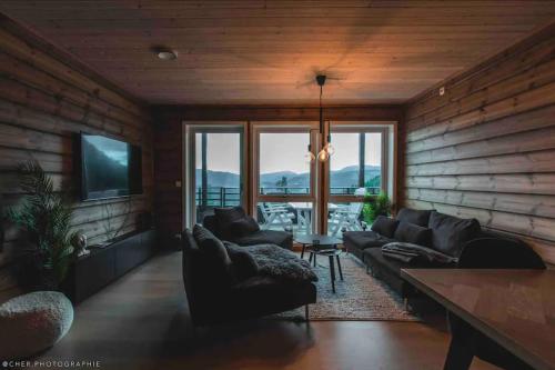 a living room with leather couches and a television at Oppgradert leilighet i Tråstølen in Skulestadmo