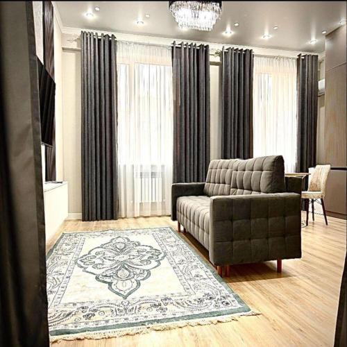 a living room with a couch and a rug at B-Group Plaza in Aktau