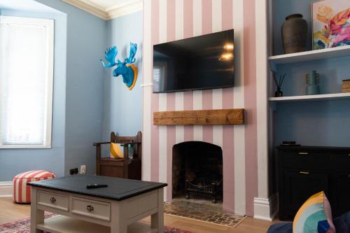 a living room with a fireplace with a tv above it at The Parade -Corner Plot Getaways in Redcar