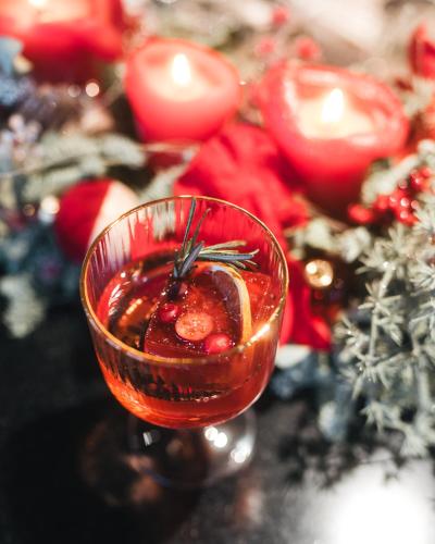 a drink in a glass on a table with christmas decorations at MOLO LIPNO RESIDENCE in Lipno nad Vltavou
