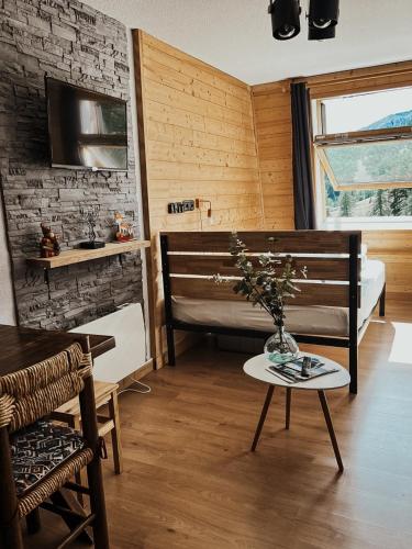 Cette chambre dispose d'une baignoire et d'une table avec une chaise. dans l'établissement LA FOUX D'ALLOS Centre station, vue panoramique Quartier les étoiles 50m des remontées, à Allos