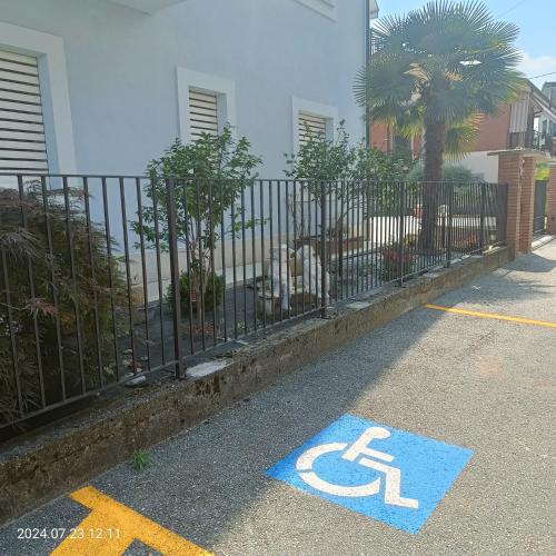 a blue handicapped sign on a sidewalk next to a fence at Villa Mariana Bed and Breakfast in Saluzzo